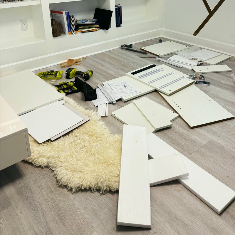 Flat-pack furniture pieces on the floor before assembly
