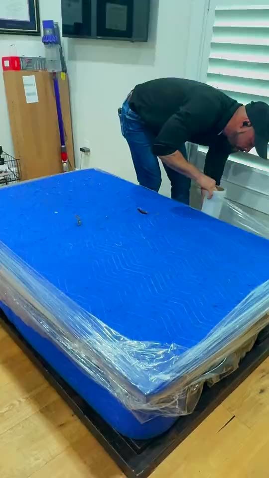 Mover wrapping a mattress in plastic