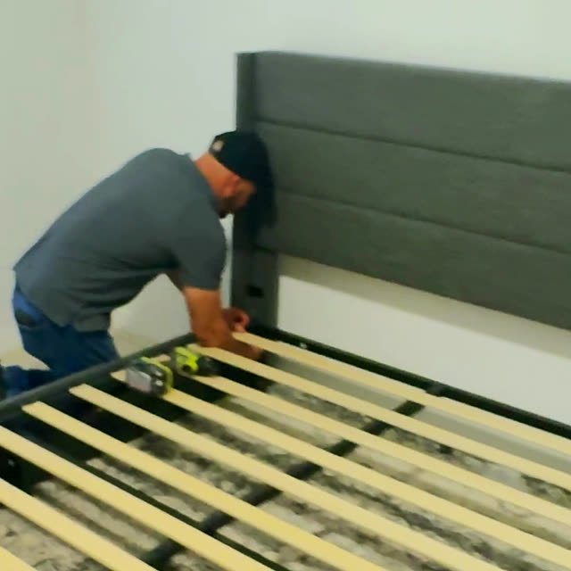 Mover putting a bed frame back together